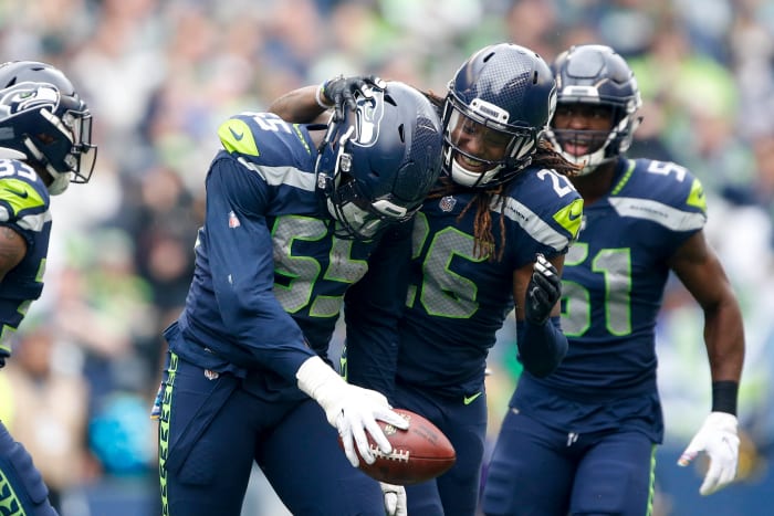 Seattle Seahawks defensive end Frank Clark (55) celebrates with cornerback Shaquill Griffin (26) after catching an interception against the Los Angeles Rams during the first quarter at CenturyLink Field.